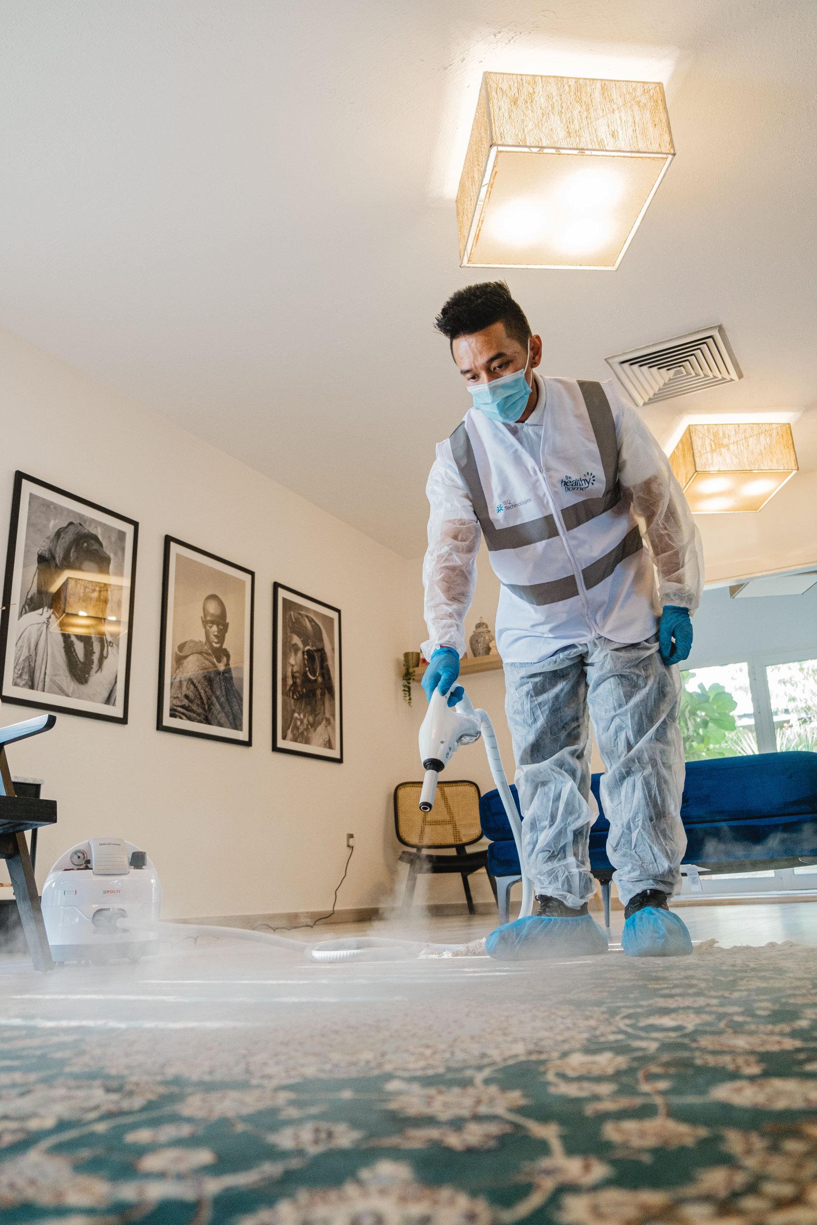Cleaner in protective equipment sanitizing a room